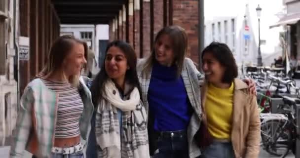 Lifestyle portrait of a diverse multiethnic group of attractive young woman friends talking together and smiling, having fun outside in a european city — Stock Video