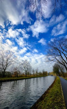 Canlı mavi bir gökyüzü ve sakin suları olan huzurlu bir kanal manzarası nefis güzellikleri yansıtıyor.