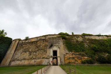 Sedan Şatosu, Sedan, Rethel, Ardennes, Grand-Est, Fransa, 28 Ağustos 2025, Surları olan tarihi taş kapı, bulutlu ve yemyeşil bir çevrede ortaçağ kalesinin Grand Stone girişi