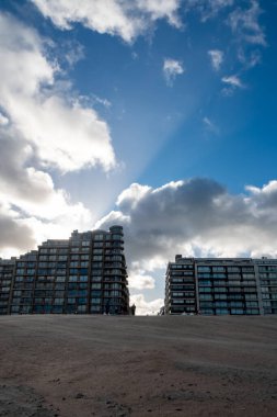 Nieuwpoort, Batı-Vlaanderen, Belçika, 25 Ekim 2025, plaj manzarası, deniz manzarası daireleri ve gökyüzü, bulutlu gökyüzüne karşı siluetli binalar