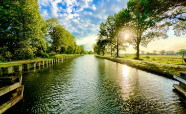 Canlı ağaçlarla çevrili sakin bir nehir manzarası. Doğanın özünü yakalıyor. Muhteşem bir görkem.