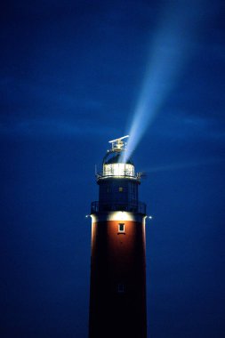 Eierland, De Cocksdorp, Texel, Hollanda, Ekim 28, 2024, göz kamaştırıcı ve görkemli bir deniz feneri karanlık gece gökyüzünde yol gösteren ışığını tüm denizlere güvenlik ışığı saçar.