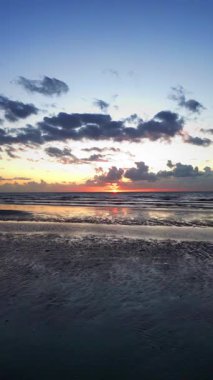 Huzurlu sahil manzarası, sakin dalgalarla sakin okyanus şafağı, sakin sahil şeridine yansıyan altın sabah ve yumuşak sörf