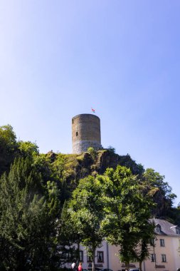 Esch-sur-Sure, Wiltz, Grand-Duche de Lüksemburg, 07 Eylül 2025, tarihi taş kulenin dikey çekimi, Mimari resim parlak mavi gökyüzü altında silindirik taş kale sergileniyor.
