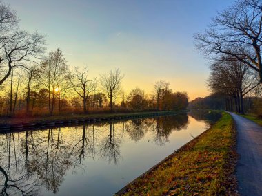Rijkevorsel, Antwerpse Kempen, Belçika, Altın Sabah Kanalı sıcak puslu ışıkla yıkandı. Sakin suyun üzerine sis yükseldi.