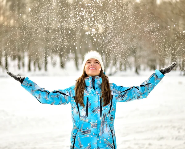 Woman blowing snow in winter park — Stockfoto