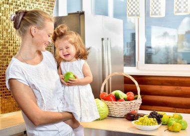 Mutlu genç anne mutfakta bir bebekle