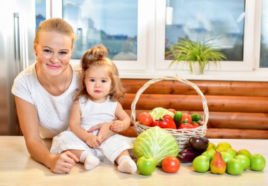 Mutlu genç anne mutfakta bir bebekle