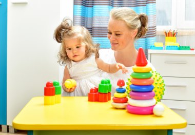 Mother and baby playing with toys
