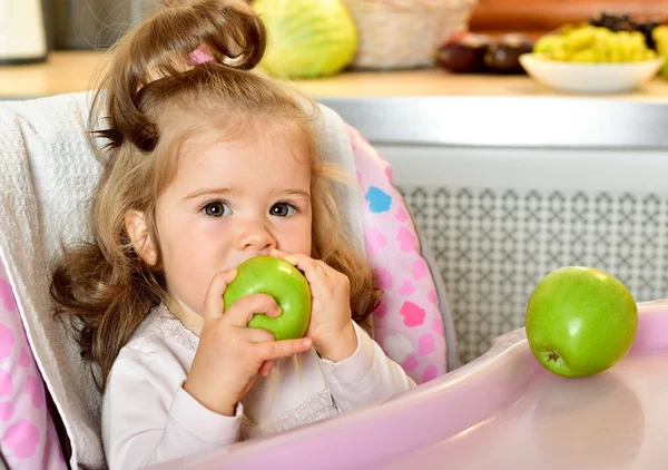 Bebê menina comer maçã verde — Fotografia de Stock