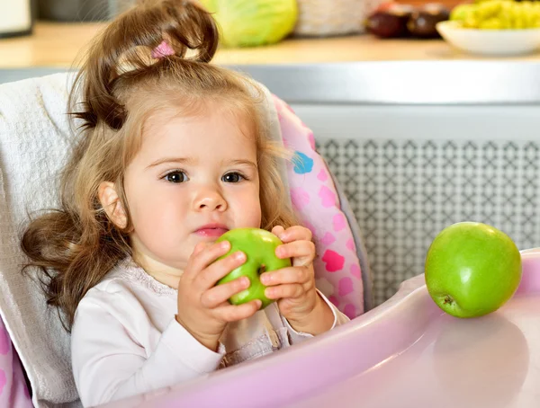 Baby girl eating green apple — Stock Photo, Image