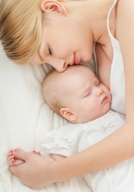 Genç anne ve bebeği yatağında uyuyan