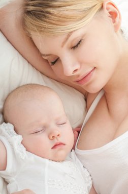 Genç anne ve bebeği yatağında uyuyan