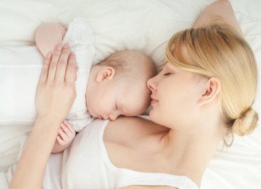 Genç anne ve bebeği yatağında uyuyan