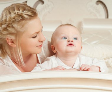 Anne ve bebek oynuyor ve gülümsüyor.