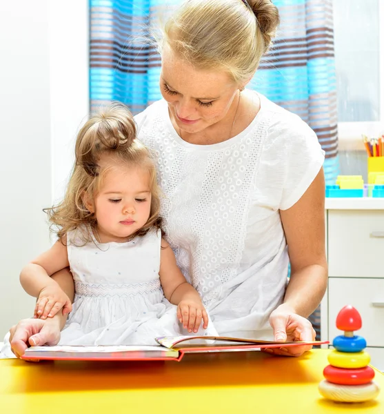 Mãe lendo um livro para filha — Fotografia de Stock