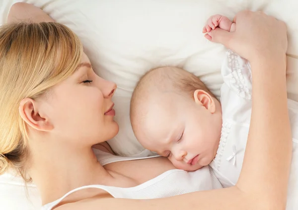 Fiatal anya és a baba alszik az ágyban — Stock Fotó