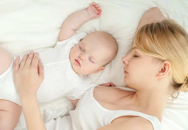 Genç anne ve bebeği yatağında uyuyan — Stok fotoğraf