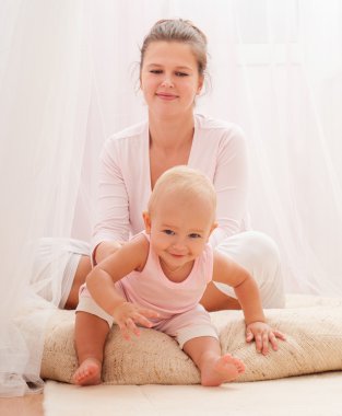 Anne ve bebek oynuyor ve gülümsüyor.