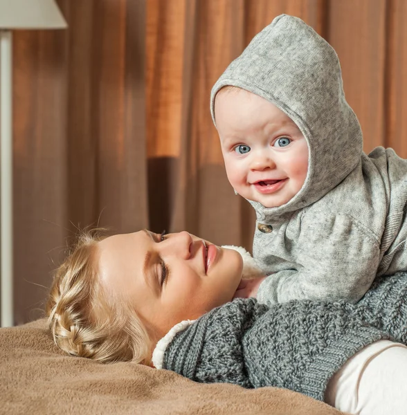 Mother and baby playing at bed — Stock Photo, Image