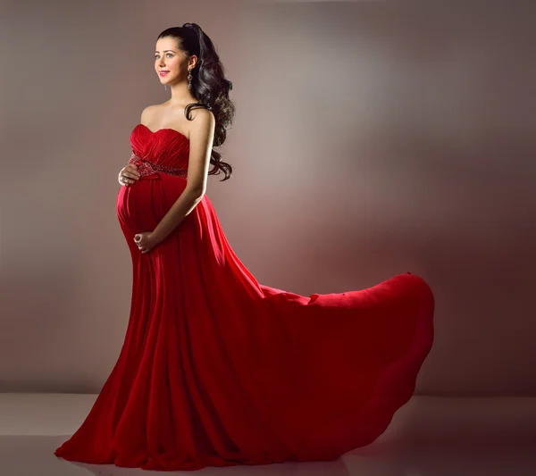 Femme enceinte en robe de soirée rouge — Photo