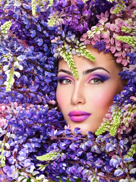 Kadının yüzüne mor çiçeklerle çevrili — Stok fotoğraf