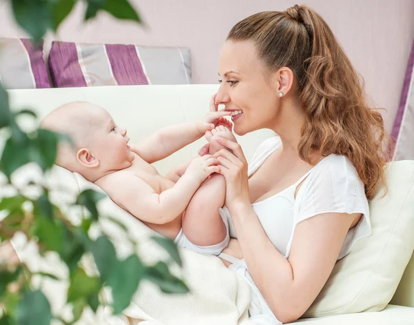 Mother and baby playing on sofa — Stock Photo, Image