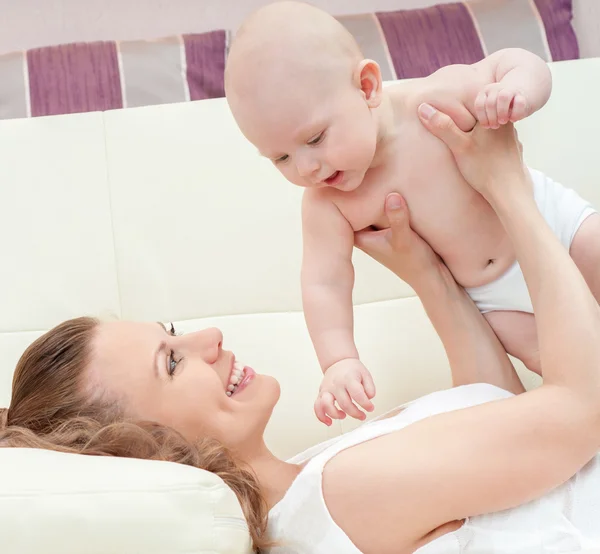 Anne ve bebek kanepenin üzerinde oynama — Stok fotoğraf