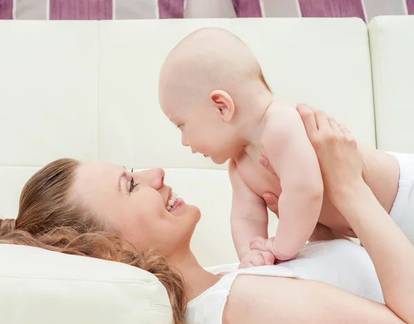 Mãe e bebê brincando no sofá — Fotografia de Stock