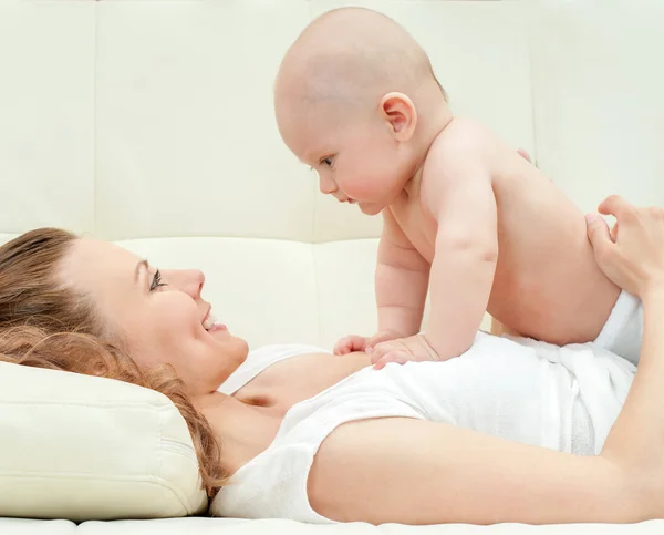 Mãe e bebê brincando no sofá — Fotografia de Stock