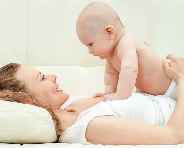 Mère et bébé jouent sur le canapé — Photo