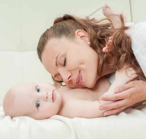 Mãe e bebê brincando no sofá — Fotografia de Stock