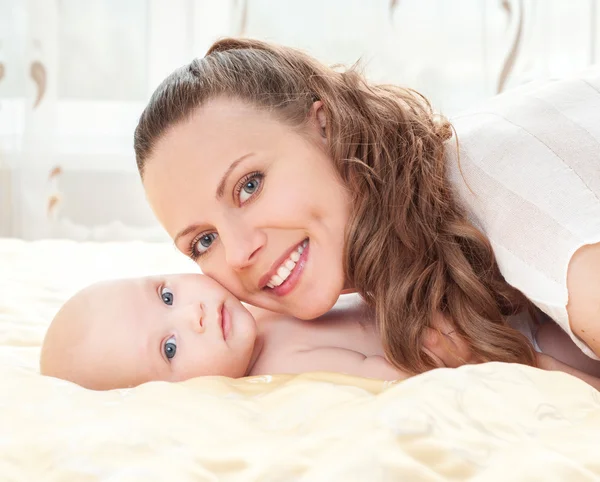 Mère et bébé jouant au lit — Photo