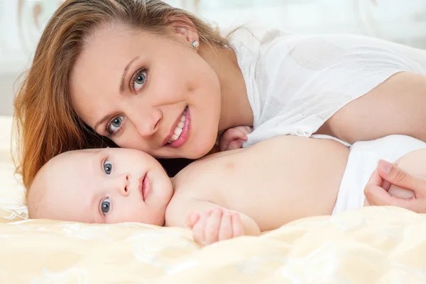 Mãe e bebê brincando na cama — Fotografia de Stock