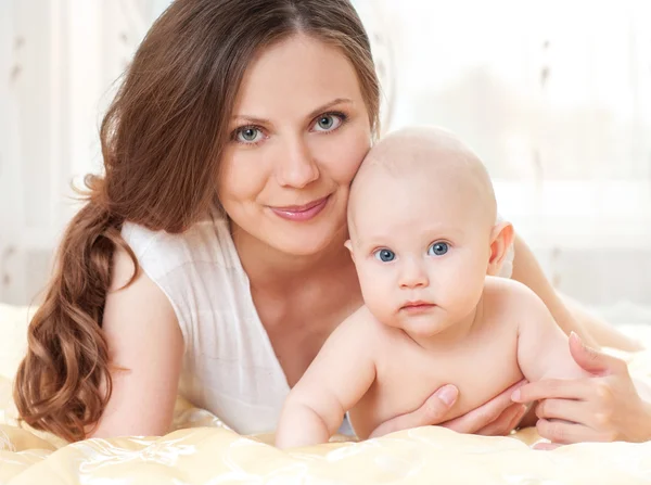 Mother and baby playing at bed — Stock Photo, Image