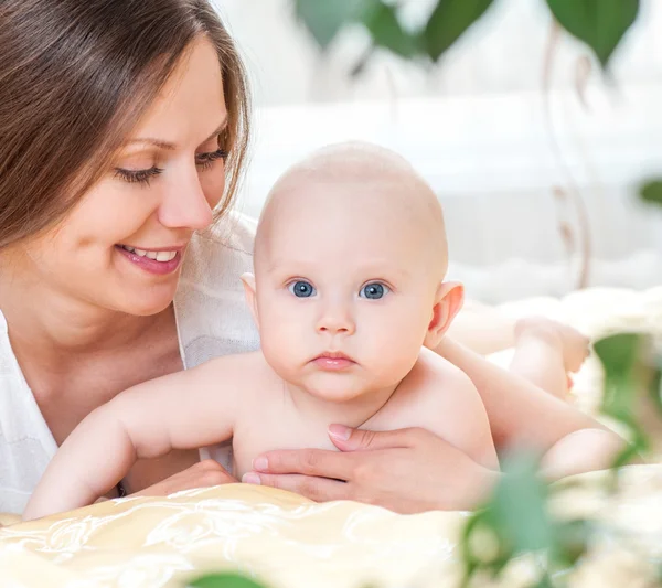 Anne ve bebek yatak oynarken — Stok fotoğraf