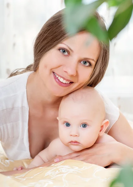 Matka a dítě hraje na postel — Stock fotografie