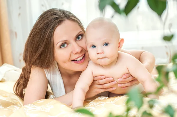 Mother and baby playing at bed — Stock Photo, Image