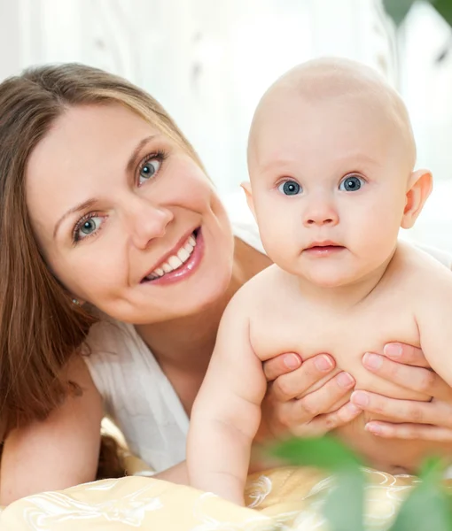 Anne ve bebek yatak oynarken — Stok fotoğraf