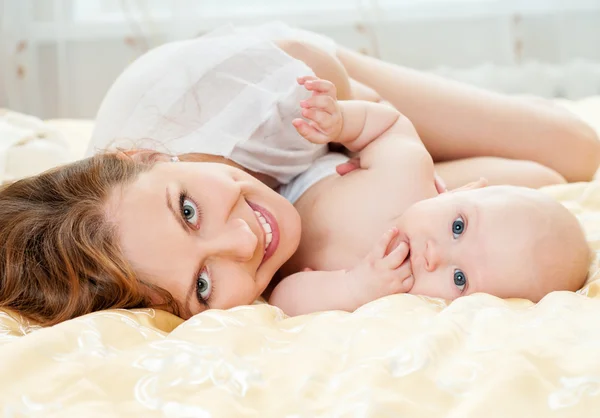 Mãe e bebê brincando na cama — Fotografia de Stock