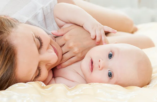 Anne ve bebek yatak oynarken — Stok fotoğraf