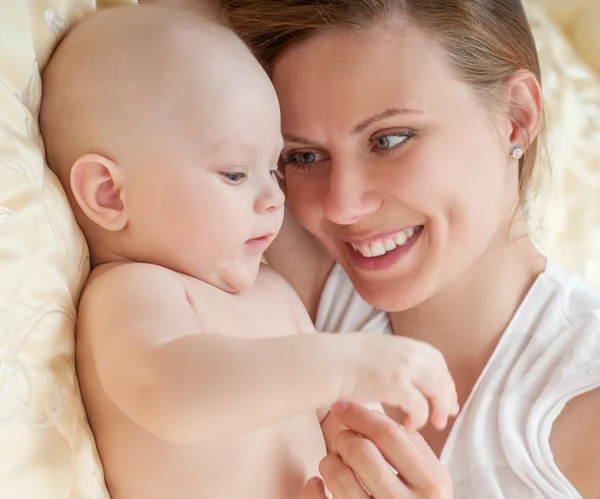 Madre y bebé jugando en la cama — Foto de Stock