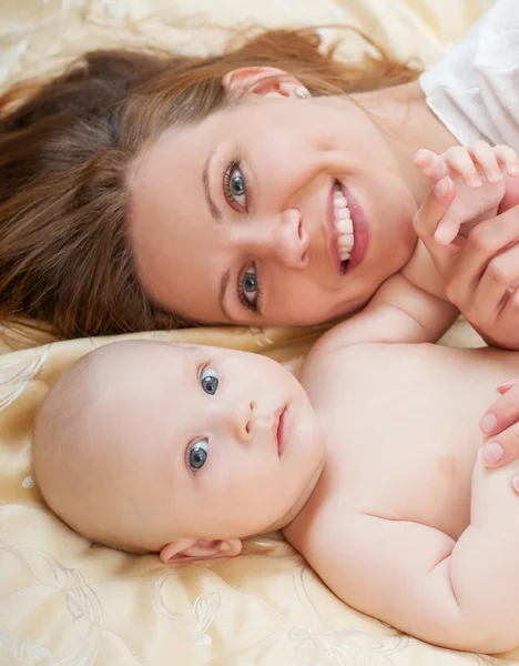 Mãe e bebê brincando na cama — Fotografia de Stock