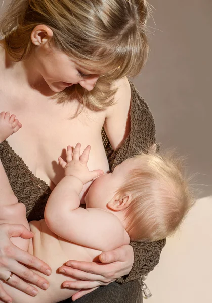 若い母親は、彼女の赤ん坊を母乳で育てる時 — ストック写真