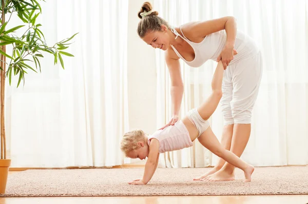 Madre e hija haciendo ejercicios de yoga —  Fotos de Stock