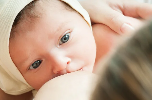 Genç breastfeeds bebeği anne.
