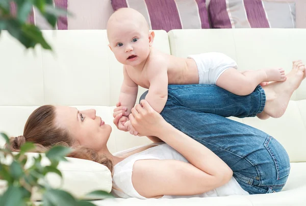 Mother and baby playing on sofa Royalty Free Stock Images