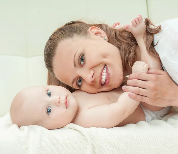 Mother and baby playing on sofa Royalty Free Stock Images