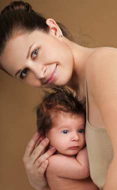 Anne ve bebek oynuyor ve gülümsüyor.