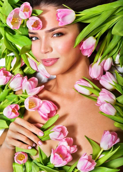 Rosto da mulher cercada por tulipas rosa — Fotografia de Stock